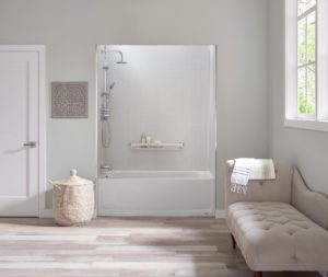 New bathtub with stainless steel hardware in light gray bathroom with beige chaise longue and wicker basket