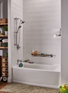 White bathtub/shower combination with stainless steel hardware. Tile-patterned wall.